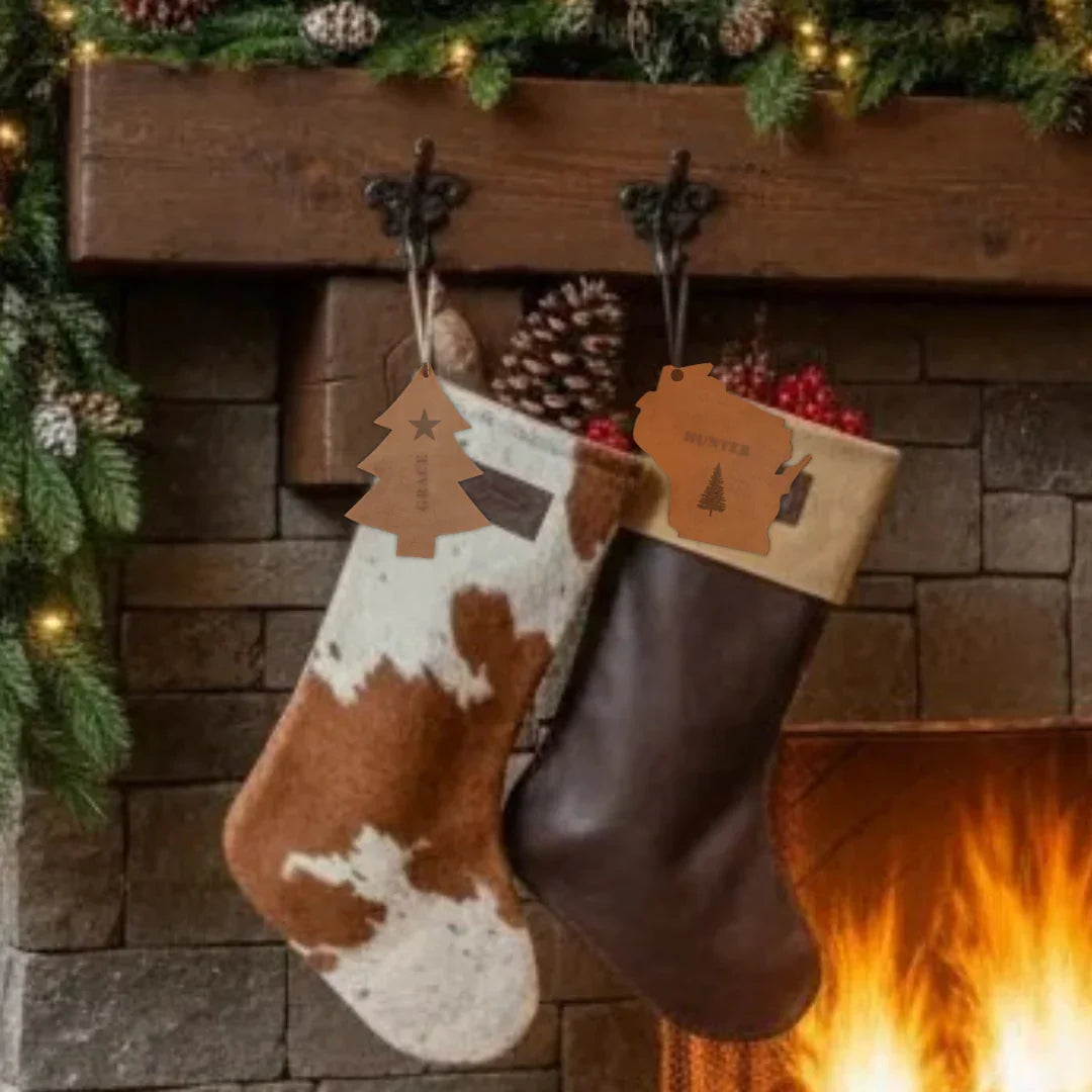 Two Christmas stockings hanging by a fireplace with a stone wall background.