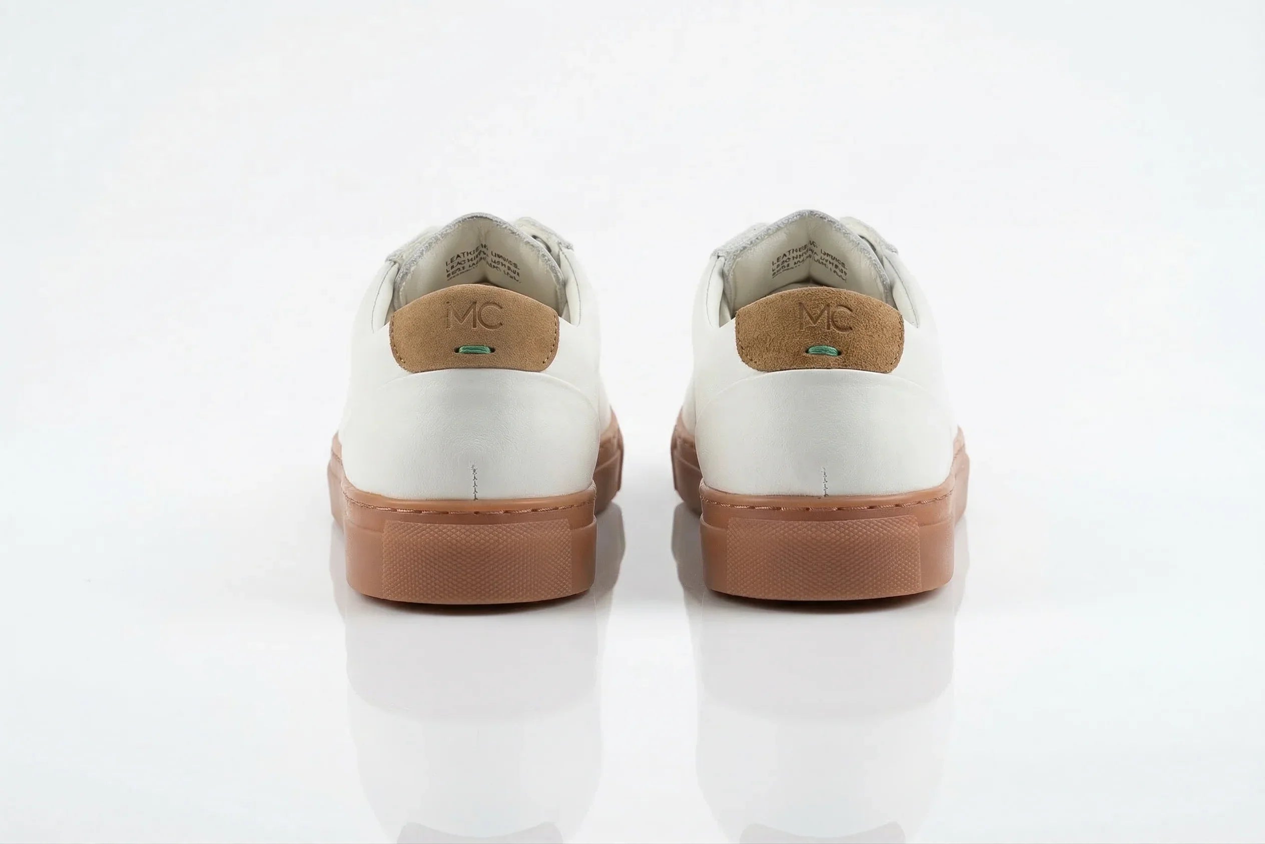 White leather sneakers with brown suede heel, gum sole, back view on white background