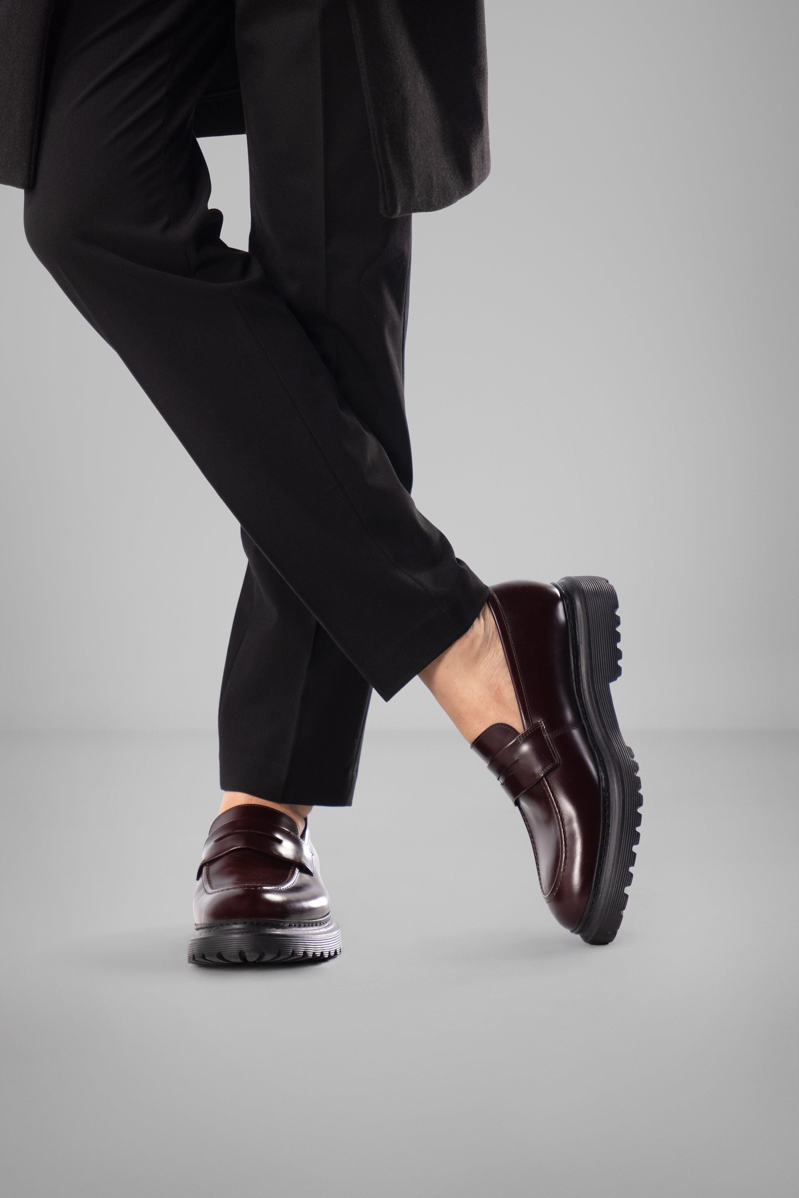 Person wearing a black suit and brown dress shoes