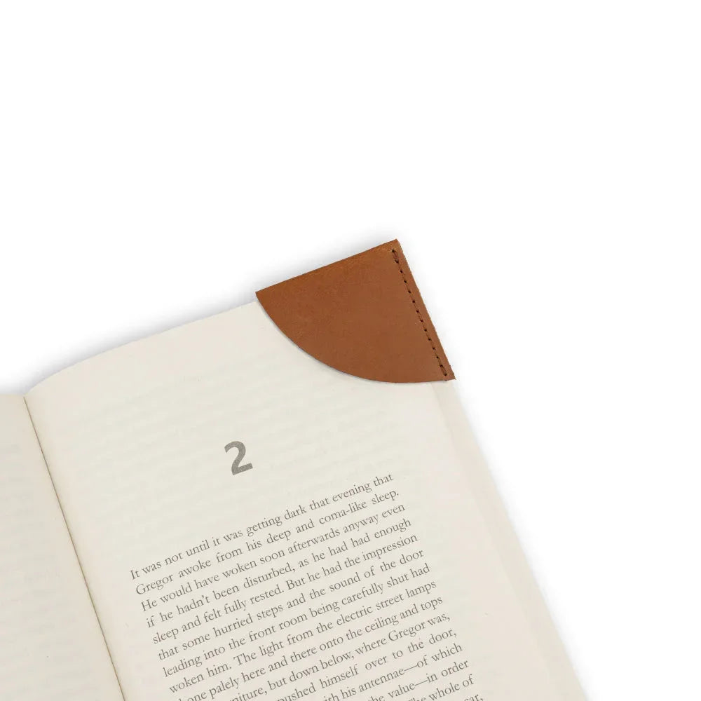 Open book with a brown leather corner bookmark on a white background