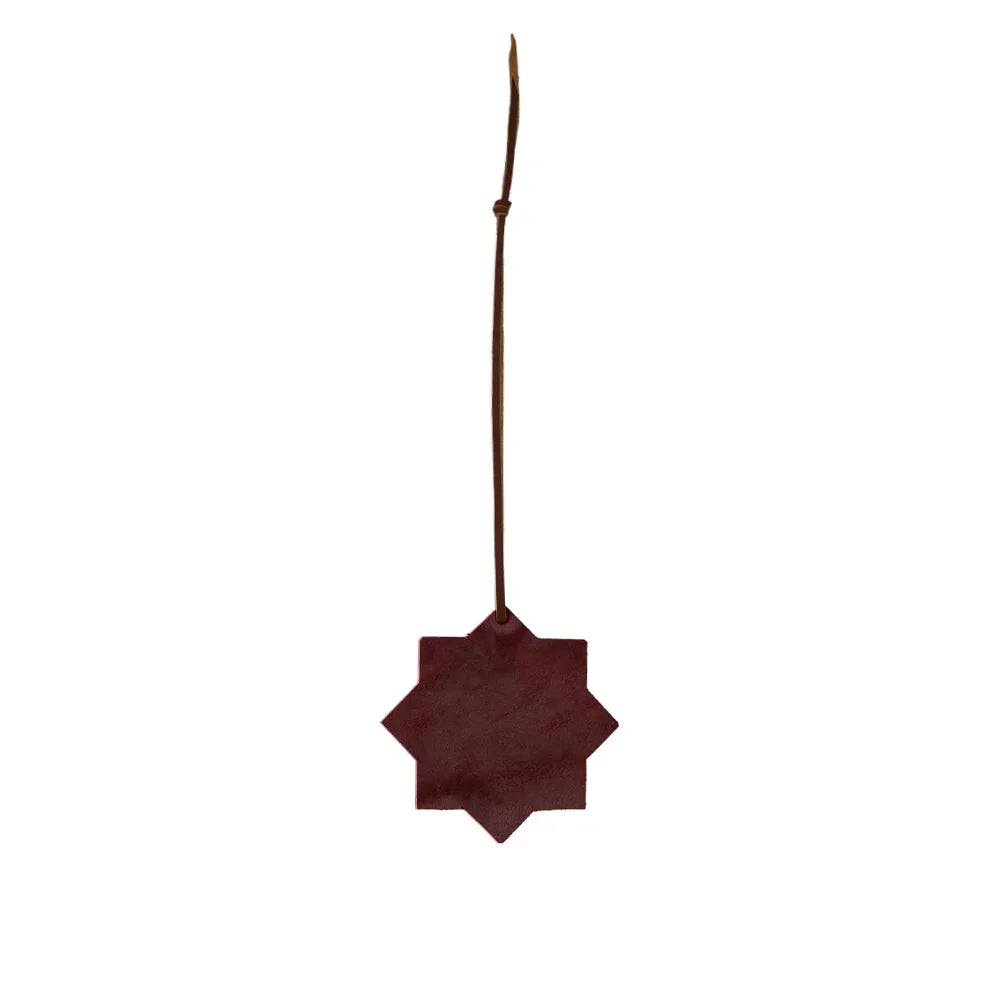 Decorative star-shaped object with a leather strap on a white background