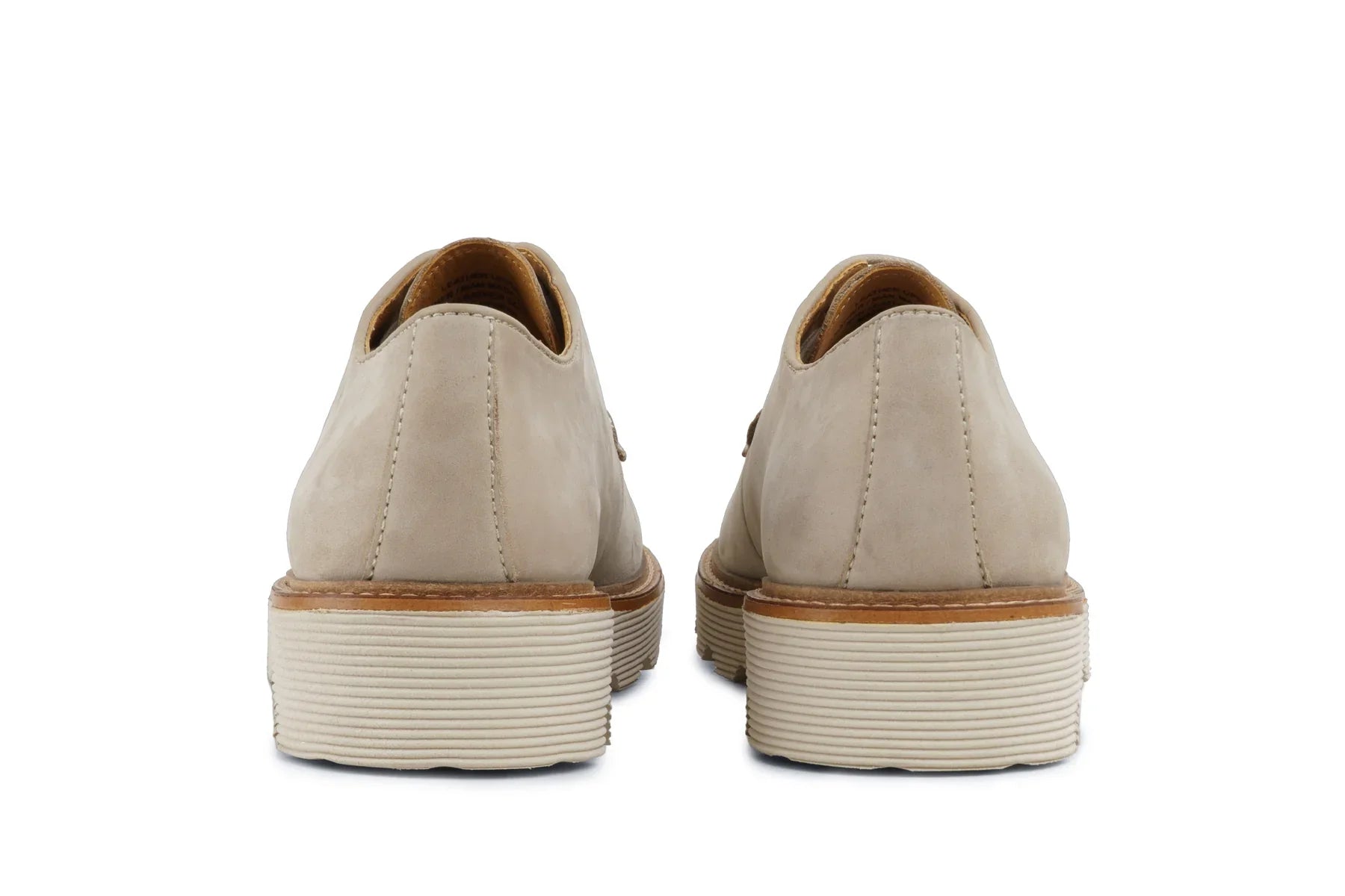 Back view of beige leather dress shoes with stacked ivory soles on white background