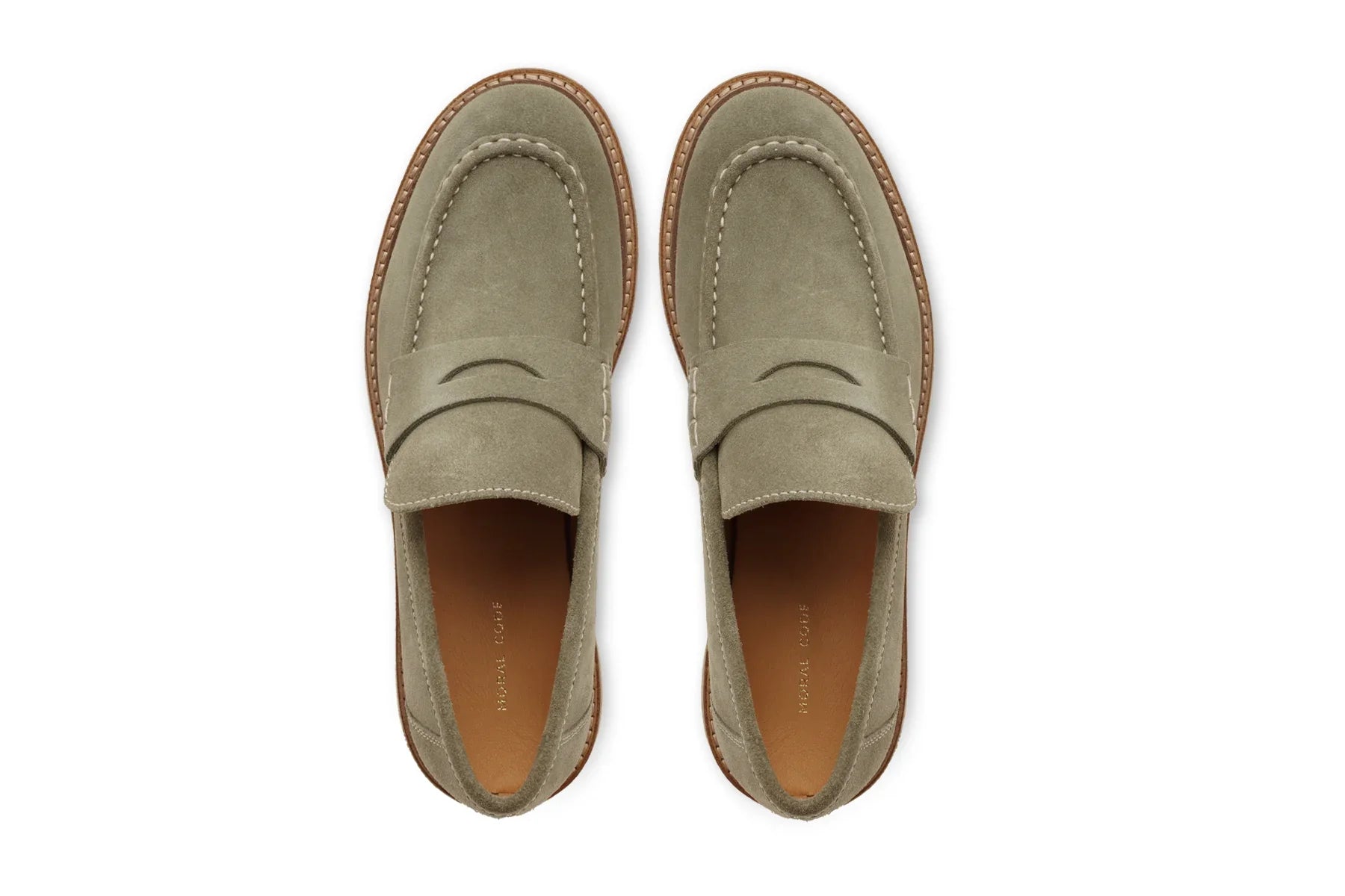 Men's light olive suede penny loafers with brown leather sole, top view