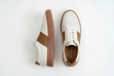 Men's white leather sneakers with brown suede accents and gum soles on white background 