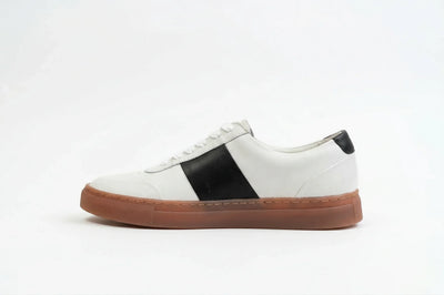 White leather sneaker with black accents and brown rubber sole on white background 