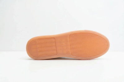 Tan rubber shoe sole with tread pattern and MC logo on a white  background 
