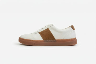 White leather sneaker with tan suede accent and brown rubber sole on white background 