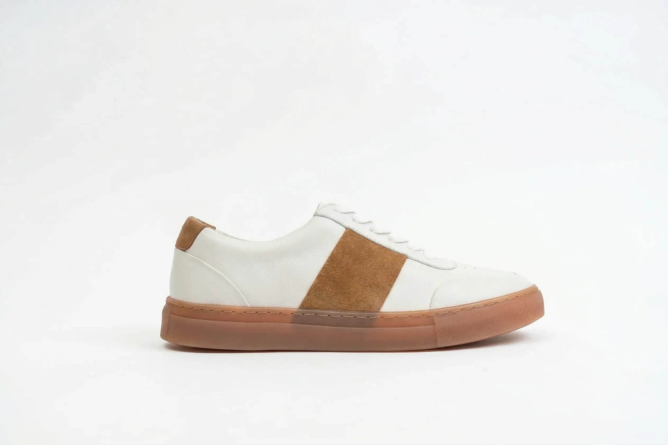 White leather sneaker with tan suede accent and gum sole on white background 