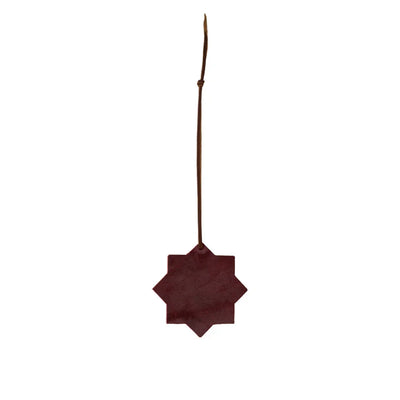 Decorative star-shaped object with a leather strap on a white background