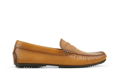 Cognac brown leather loafer with moc toe stitching and rubber sole, side view on white background  