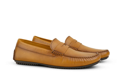 Men's cognac leather penny loafers with moccasin stitching on white background 
