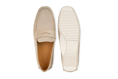 Beige suede penny loafer shoes with rubber sole, flat lay on white background 