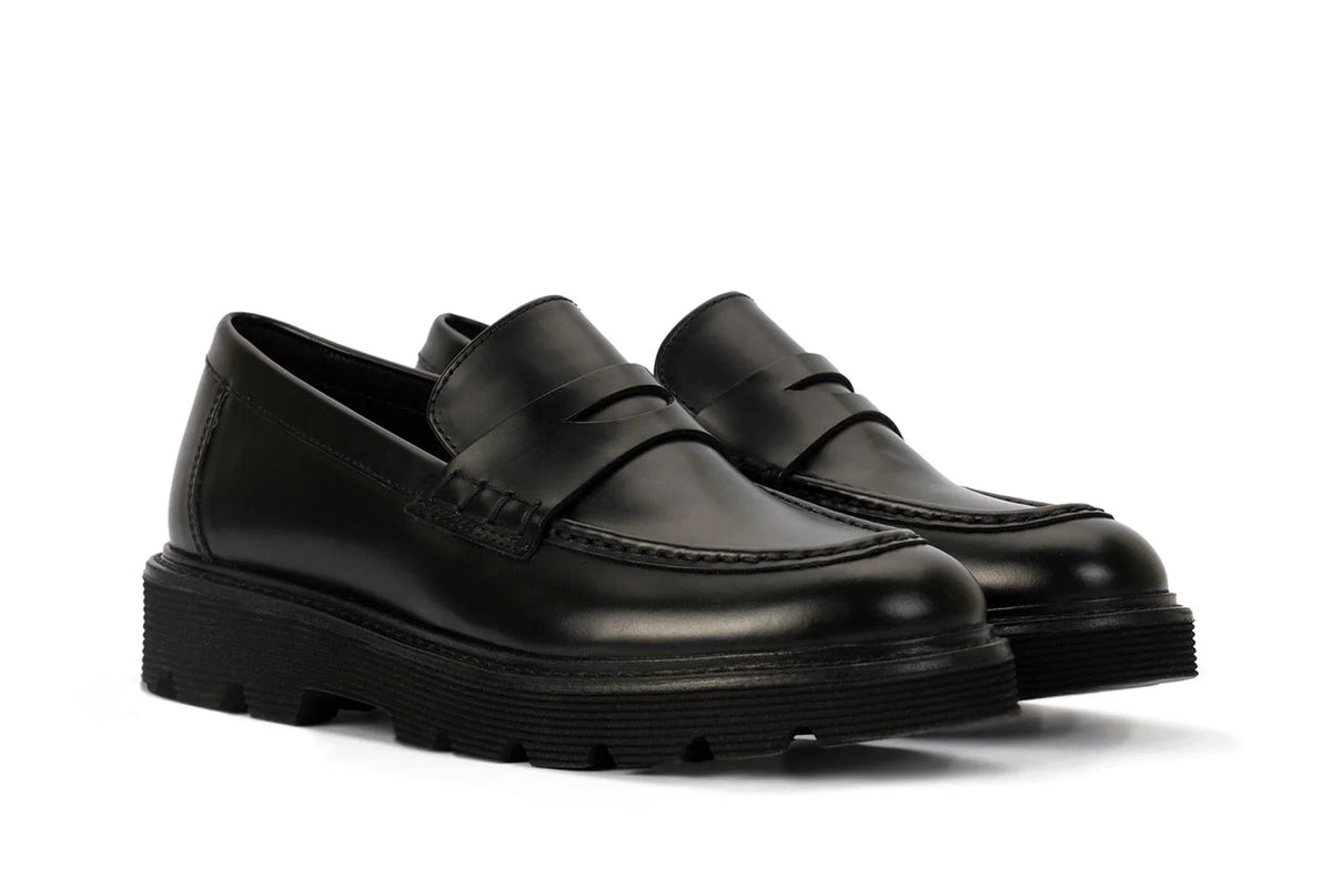 JustFab Black glossy penny loafers with chunky lug soles and contrast stitching. The 10 Best Chunky Loafers of 2026, According to Fashion Editors main image 4