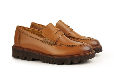Men's cognac brown leather loafers with chunky rubber sole and classic penny strap design 