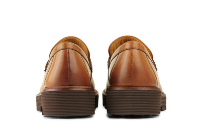Back view of brown leather loafers with stacked rubber soles on white background 