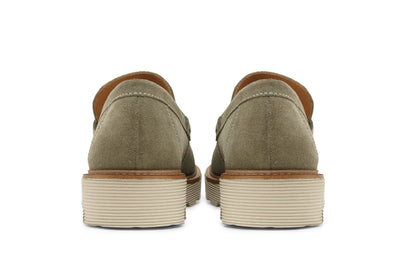 Back view of light olive suede leather loafers with stacked rubber soles on white background  