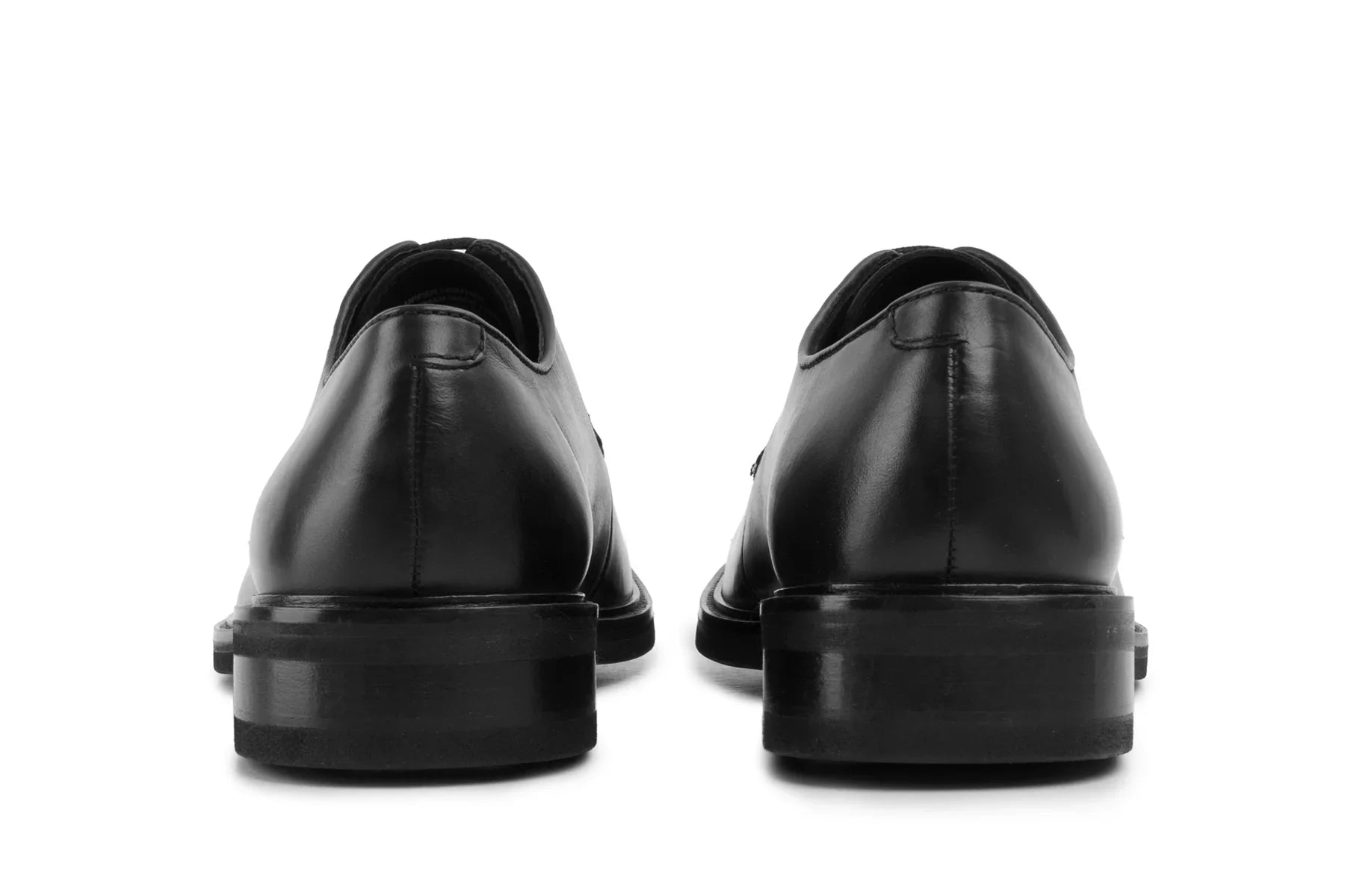 Back view of black leather dress shoes with polished finish on white background  