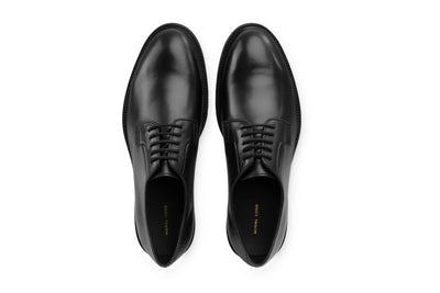 Black leather lace-up dress shoes for men, top view, minimalist style
