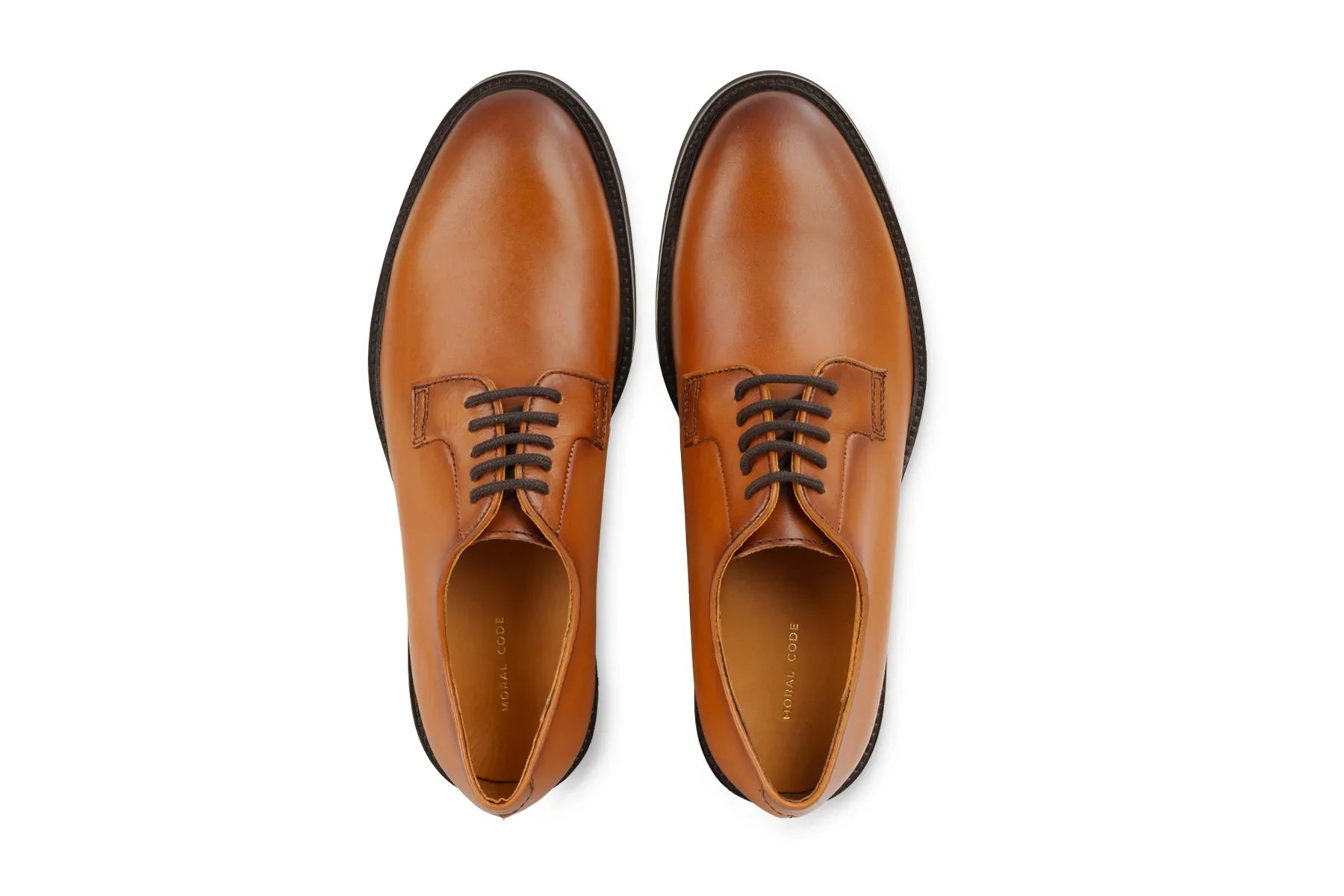 Pair of men's cognac brown leather dress shoes with black laces on white background  