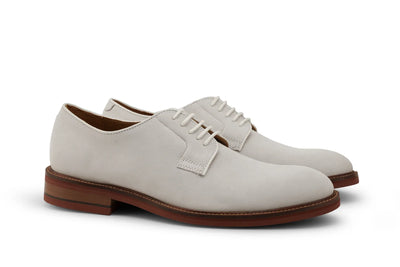 Ivory suede Derby dress shoes with brown leather soles, classic lace-up design on white background
