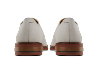 Back view of ivory leather derby shoes with stacked wooden soles on white background 