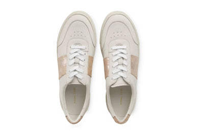 Pair of white leather sneakers with beige accents and white laces, viewed from above 